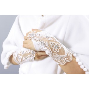 Białe rękawiczki komunijne z ozdobą na nadgarstku.
